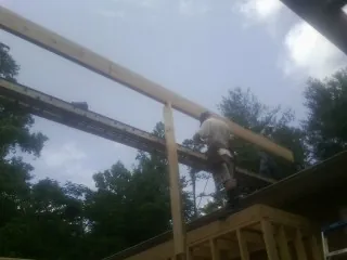 Carpenter setting a ridge beam over a new addition frame — Ice Dam Removal by Roofing Brothers in Mount Tremper